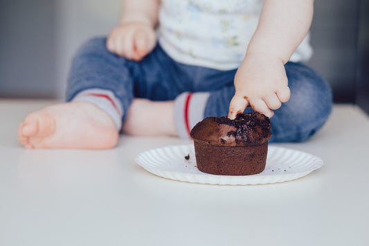 Un bébé met le doigt dans un gâteau au chocolat 